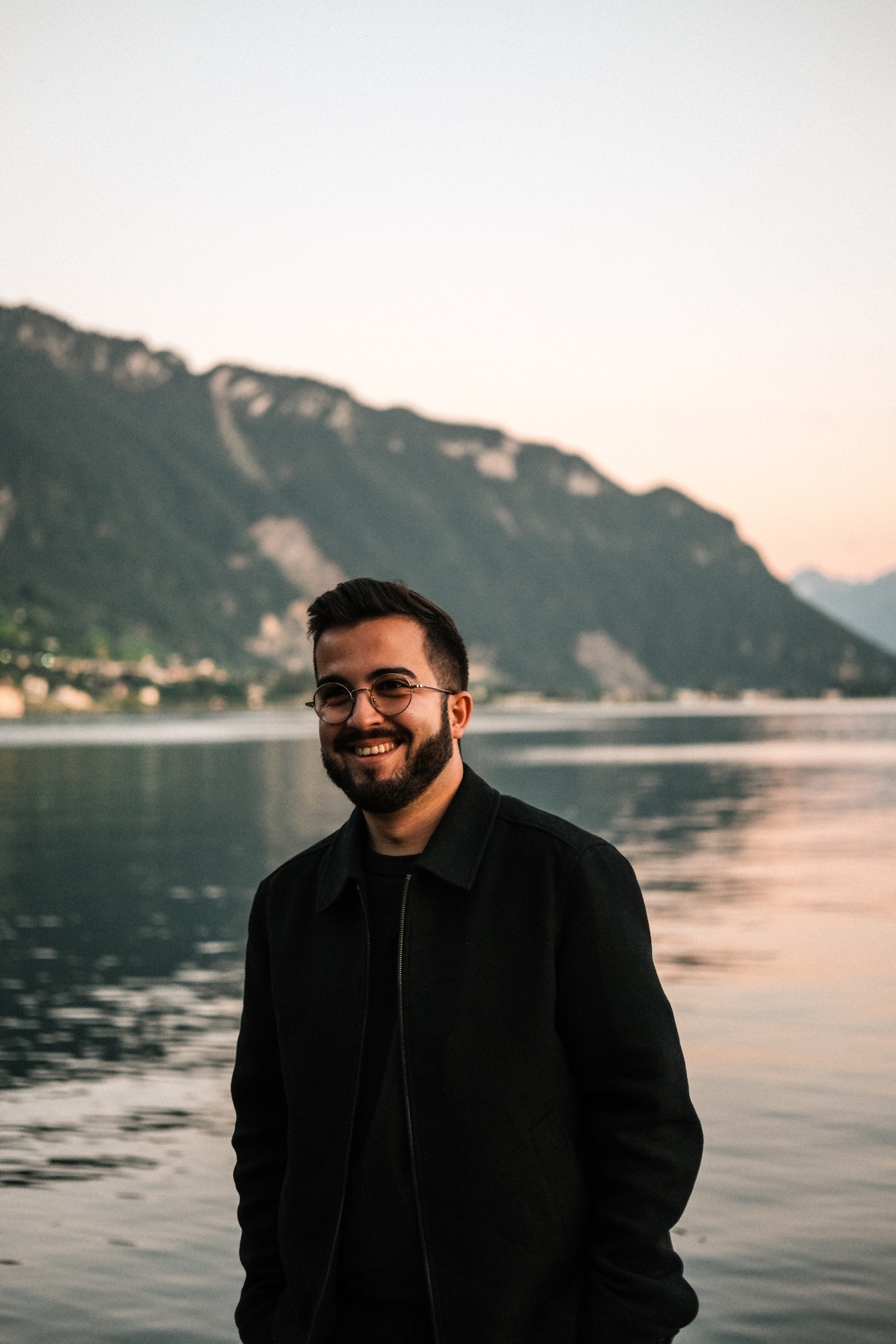 François Allet, souriant au bord d’un lac avec les montagnes en arrière-plan